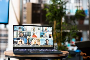 İş adaylarıyla video konferansı düzenleyen yönetim kurulunu gösteren dizüstü bilgisayara odaklan. Video görüşmesi sırasında HR çalışanlarının röportaj yaptığını gösteren defter ekranını kapat