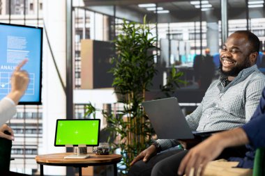 Mutlu yöneticinin yanındaki izole ekran tableti çalışanla konuşuyor, şirket yönetimini koordine ediyor. Jolly denetçisi iş prosedürlerini gözden geçirirken işçiyle sohbet ederken eğleniyor.