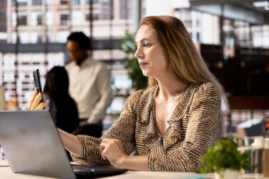 CEO akıllı telefonlar üzerine video konferansı düzenliyor uzaktan kumandayı denetliyor ve kilit iş stratejilerini tartışıyor. Sanal bir toplantıda hedefler ve hedefler belirleyen genel müdür.
