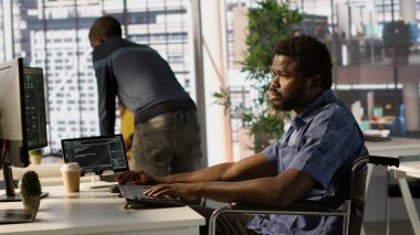 Makine öğrenme teknolojisiyle çalışan engelli bir yazılım teknisyeni. Tekerlekli sandalyedeki belden aşağısı felçli Afrikalı Amerikalı bilişim uzmanı verileri tahmin edilebilir modellere dönüştürüyor