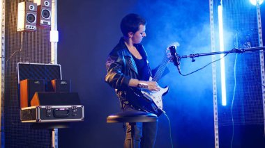 Sinirli bayan sanatçı bir gece kulübünde akustik gitar çalıyor, ateşli enerji ve moda ile performans sergiliyor. Alternatif müzik söyleyen şarkıcı heavy metal sanatçısı, vahşi atmosfer. Kamera A.