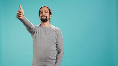İyimser bir adamın portresi işaret işareti, mutlu bir yüz ifadesi ve tatmin. Neşeli bir Arap heyecanlı, el hareketi yapıyor, stüdyo geçmişi, kamera B
