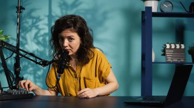 İçerik yaratıcısı podcast kayıt ekipmanları hazırlıyor, misafirlerin gelmesini ve video çekmesini bekliyor. Stüdyo B 'de röportaj yapmadan önce ev sahibi profesyonel mikrofonu test ediyor.