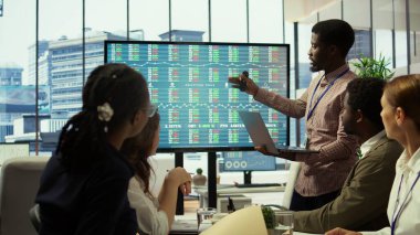 Kurumsal brifing raporlarını tartışmak ve yenilikçi fikirleri paylaşmak için toplantı odasında çeşitli çalışma grupları toplandı. Çalışanlar önümüzdeki çeyrek için etkili bir pazarlama stratejisi planlıyor. Kamera B.