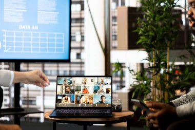 Ofis memurları telekonferans toplantısı sırasında ofisteki belgelerin gelir rakamlarını inceliyor. Uzak video çağrısı sırasında şirket istatistiksel numaralarını karşılaştıran personel üyeleri