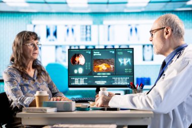 Kıdemli pratisyen hekim, kontrole gelen kadına destek ve reçeteli ilaç teklif ederek bir kutu takviye ve antibiyotik veriyor. Uzman, doğru dozajda haplar öneriyor..