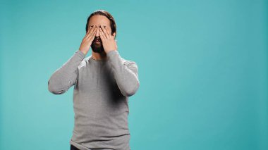 Gözlerini, kulaklarını ve ağzını kapayan adam üç bilge maymunu taklit ediyor. Görmeyen, duymayan ve konuşmayan Araplar el hareketi konsepti, stüdyo arka planı, kamera B