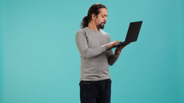 E-posta yazan, dizüstü bilgisayarda yazan, işten sonra oturumu kapatacak olan bir adam. Çevrimiçi e-posta gönderen neşeli kişi, beyin fırtınası fikri, stüdyo arka planında izole edilmiş, kamera A