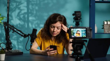 Streamer canlı yayın yapıyor, cep telefonu ekranından ilginç mesajlar okuyor. Sosyal medya paylaşımları hakkında cep telefonuyla konuşan, izleyicilerle konuşan, kamera A