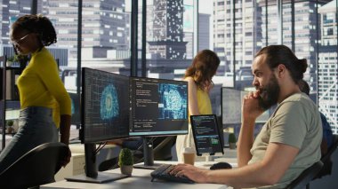 Makine öğrenme modellerini eğitmek ve yerleştirmek için yapay zeka kaynakları ve platformları kullanan çalışanlar, el kamerası görüntüleri. Yapay zeka şirketi sistemlerini izleyen ve devam ettiren adam, kamera B