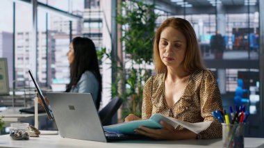 İş yerindeki satış müdürü, ofisinde strateji planlamasını kesinleştiriyor. Rapor yazıyor ve e-postaları cevaplıyor. İşçi proje yönetiminde işbirliği yapıyor, kararları yönlendirmek için verileri kullanıyor. Kamera A.