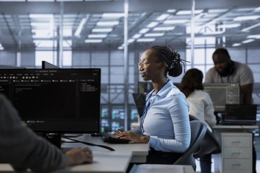 Sunucu çiftliğindeki programcı enerji tüketimini azaltmak için güç yönetimi çözümleri uyguluyor. Yeni teknoloji ve sistemleri veri merkezine entegre eden Afrikalı Amerikalı çalışan