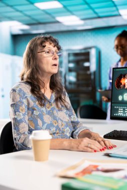 Kıdemli kadın hasta doktoruna yeni bir tedavi planı soruyor, sağlık kayıtlarını ve tarama sonuçlarını değerlendiriyor. Tıbbi uzman, hastaya iyileşme yolunda rehberlik ediyor..