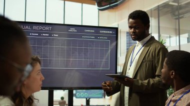 Bir şirkette problem çözme toplantısına katılan iş arkadaşları, verileri görselleştirmek ve karmaşık zorluklar için çözümler geliştirmek için etkileşimli bir kurul kullanıyorlar. Analiz sunumu. Kamera B.