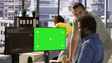 Yeşil ekranda yazılım hata ayıklaması yapan yönetici, iş arkadaşından yardım istiyor, koddaki hataları kontrol ediyor. İşçi, bilgisayardaki kodlama hatalarını düzeltiyor. Meslektaşı kamera A 'nın yardımıyla.