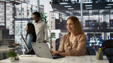 Şirket masasında oturan kendine güvenen yetenekli girişimci, iş büyümesini tahmin etmek için dizüstü bilgisayarını kullanıyor. Finansal planlamayı yönetmek ve hedeflere ulaşmak. Kamera B.