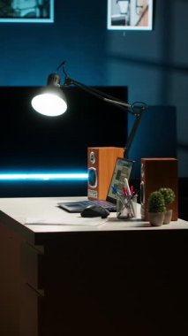 Konforlu dekorlu, ahşap mobilyalı, akıllı televizyonlu ve bitkilerli modern ev ofis düzenine sahip dikey video geniş dairesi yaratıcı bir yaşam tarzı ve konforu harmanlıyor. Minimalist alan.