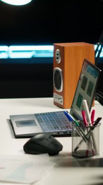 Dikey Görüntü Boş ama çağdaş aydınlatılmış bir dairede ev ofisini davet ediyor. Ahşap döşemeler, modern mobilyalar ve dekoratif bitkiler kapalı alanda çalışmak için rahat bir çalışma alanı oluşturuyorlar..