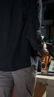 Dikey Video Uzaktan Çalışanı, proje verilerini düzenliyor, el yazısıyla yazdığı notları inceliyor, internette araştırma yapıyor. Serbest çalışan siyahi kişi serbest işini ve evdeki günlük programını yönetiyor.