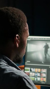 Dikey Video Genç Adam video yapımcısı çift monitörlü bir film montaj projesi üzerinde çalışıyor. Erkek görüntüler editörü sinematik yaratıcılık sürecini başlatıyor, film düzenleme endüstrisi