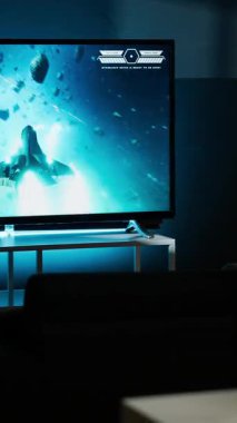 Dikey Videocu Adam TV 'de çok oyunculu video oyunları oynayarak, konsolunu akıllı televizyona ayarlayıp geceleri oyun oynayarak vakit geçiriyor. Nişancı yarışmasında dövüşen oyuncu. Kamera B.