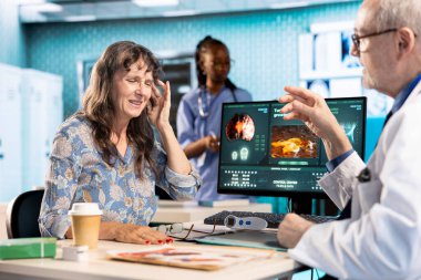 Baş ağrısı çeken yaşlı bir hasta ve sağlık kontrolünde tavsiye istiyor. Genel pratisyen, ağrıyı azaltmak ve iltihabı azaltmak için bir tedavi öneriyor. Sağlık sigortası.