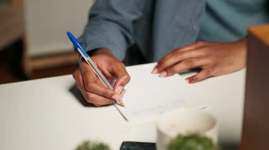 Odaklanmış serbest çalışan yetişkin araştırmaları evdeki verileri araştırıyor, el yazısıyla notlar yazıyor ve uzaktan kumandasındaki görevleri çözüyor. Şık bir daireden projeleri yönetiyor. Kamera B.