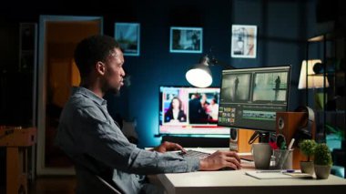 Genç adam video editörü, film çekimlerinin montajında çalışıyor, post prodüksiyon sahneleri için serbest kontrat yapıyor. Beyaz dengesi ve renk derecelendirme düzenleyici, bilgisayar yazılımı. Kamera A.