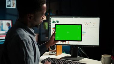 Finansal elementleri inceleyen bir erkek uzman. Gelir artışı için stratejik rapor hazırlıyor. Afrikalı Amerikalı finansör sermaye fonlarının dengesini uzaktan kontrol ediyor. Kamera A.