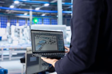 Fotovoltaik fabrikasındaki mühendis arızalı sistemleri tespit etmek için dizüstü bilgisayardaki izleme yazılımını kullanıyor. Güneş panelleri üreten fabrika işçisi, izin süresini azaltmak için dizüstü bilgisayar kullanıyor