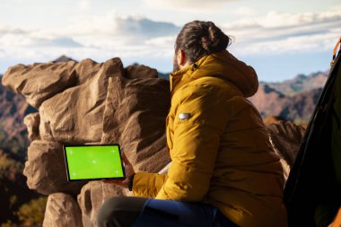 Kararlı dağcı, kişisel gelişimin yürüyüş yolculuğundan esinlenerek yeşil ekranın yanındaki dağ zirvelerinin keyfini çıkarıyor. Erkek yürüyüşçülerin macerası ve açık havanın güzelliği.