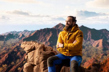 Sıcak giysili maceraperest, vahşi doğanın huzurunu, panoramik dağ manzarasını ve açık gökyüzünü sever. Rahatlamak için mükemmel bir ortam yaratır. Soğuk rüzgarlar yokuş yukarı.