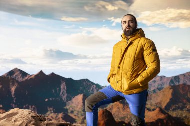 Genç gezgin, yüksek dağ zirveleri ve açık gökyüzü ile çevrili destansı manzarası ile vahşi doğada huzurlu bir anın tadını çıkarıyor. Yüksek irtifada macera arayan, korkuları yenen.