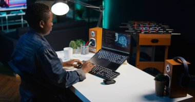 AI uzmanı Java programlama dillerini kullanarak daire ofisindeki dizüstü bilgisayarına kod yazar. Yapay zeka programcısı evde çalışırken uzaktan veri tabanı hatalarını düzeltmeye çalışıyor, kamera B