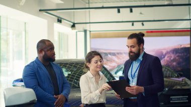 Araba galerisi satıcısı müşterilerine arzu edilen aracın markasını, tipini ve kalitesini belirlemek için sorular soruyor. Ajans müşterileri memnun ediyor, soruları cevaplıyor, kamera A