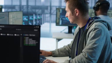 Bilgisayar ekranına bakan bilişim teknisyeni, ağ güvenlik veri merkezinde çalışıyor, en iyi performansı sağlıyor. Sunucu merkezini denetleyen, sondaj kulesi boyunca enerji tüketimini izleyen, kamera A