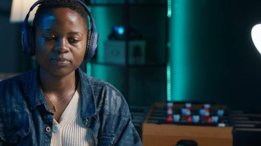 Teleworker şirket projesi için verileri araştırırken müziğin tadını çıkarıyor, bir gecede kişisel ev ofisinde görevler yapıyor. Dizüstü bilgisayarın önünde oturan ve kulaklık ve kamera A kullanan bir kadın.