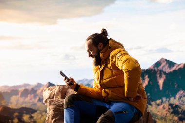 Trekker, yüksek rakımlı hava ve nefes kesen manzaranın farkındalığı teşvik ettiği dağlarda sakin bir anın tadını çıkarıyor. Rahatlama ve doğada kendini geliştirme.
