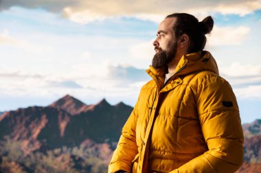 Kararlı gezgin, gökyüzünün enginliği ve engebeli zirvelerden esinlenerek destansı dağ sırasına ve manzaraya bakıyor. Yürüyüş yaparken büyük açık havayı kucaklamanın ödülü..