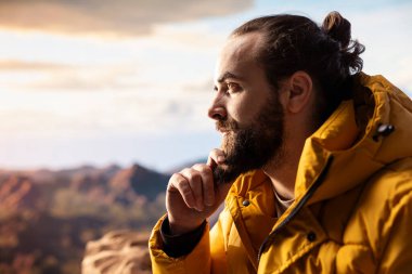 Genç gezgin yüksek rakımlı yabanın, çarpıcı manzaranın ve huzurlu çevrenin tadını çıkarıyor. Doğa aşığı dağın zirvesine tırmanırken mutlu hissediyor kendini..