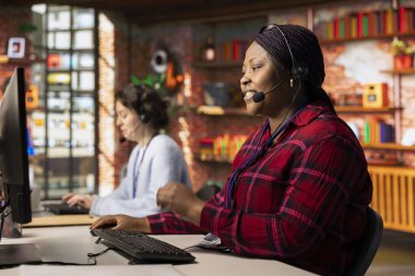 Happy çağrı merkezi çalışanı müşteri geri bildirim verilerini analiz eder, şikayetleri azaltmak için çalışır. Bilgisayar masasındaki arkadaş canlısı müşteri hizmetleri çalışanı müşteri ihtiyaçlarını gidermek için problem çözme becerilerini kullanıyor