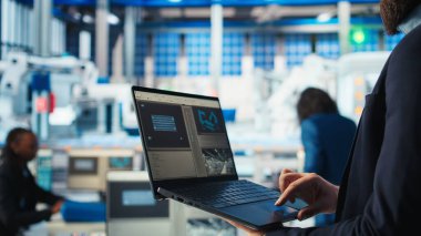 Fotovoltaik fabrikası çalışanı verileri analiz ediyor, sistem sağlık ölçümlerini dizüstü bilgisayarla inceliyor. Güneş panelleri fabrika çalışanlarının teknik sorunlarını dizüstü bilgisayar ve kamera kullanarak çözüyor.