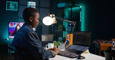 Yazılım geliştiricisi Java programlama dillerini kullanarak daire ofisindeyken laptop ekranına kod yazar. Programcı, evde çalışırken veritabanı hatalarını düzeltmeye çalışıyor, kamera B