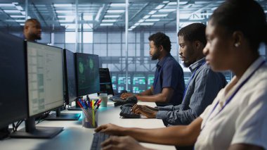 Sunucu odasında bilgisayar korsanlarının veri çalmasını engellemeye çalışan siber güvenlik uzmanları. Veri merkezindeki programcılar, şirket sunucularına saldıran virüsü silmek için ekip çalışması yapıyorlar. Kamera A.