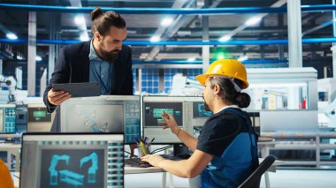 Fotovoltaik fabrikası mühendisi CAD yazılımında tesis katında çalışmayı planlıyor, takım liderini gösteriyor. Güneş panelleri üretim fabrikası teknisyeni montaj hatları dizayn ediyor, bilgilendirme müdürü, kamera A