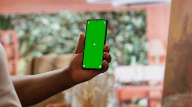 Afrikalı Amerikalı ressam atölyesinde fotokopi ekranı olan bir cihaz kullanarak tuvalde ilham verici yeni şaheseri üzerinde çalışıyor. Atölyedeki suluboya boya ve yaratıcılığı kullanarak. Kamera A.