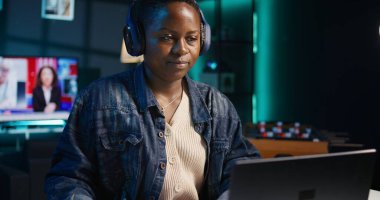 Girişimci evde çalışıyor, dizüstü bilgisayar kullanıyor ve kağıda notlar yazıyor. Kişisel apartman dairesindeki uzaktan çalışan, e-postaları cevaplayan ve not defterine önemli bilgiler yazan, B kamerası.