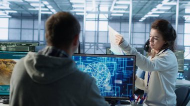 Yönetici ofisinde teftiş yapıyor, BT çalışanı tarafından yapay zeka difüzyon uygulaması oluşturulup yapılmadığını kontrol ediyor. Ekip lideri denetleme mühendisi yapay zeka üreten yazılım üreten video, kamera A