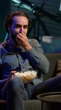 TV 'de film izlerken ve patlamış mısır yerken apartmanda yemek yiyen dikey videocu adam. Yemek yerken boğazı tıkanan, kanepede Heimlich manevrası yapan, onun için savaşan biri.