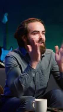 Dikey video Heyecanlı hayranlar TV 'de canlı yayında en sevdikleri takımı destekliyor. Evde pijama giyen, enerjik el hareketleri yapan, kendi kulübü için tezahürat yapan bir destekçi.